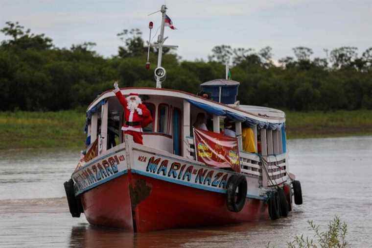 Brazil |  Amazonian Santa Claus distributes gifts by boat