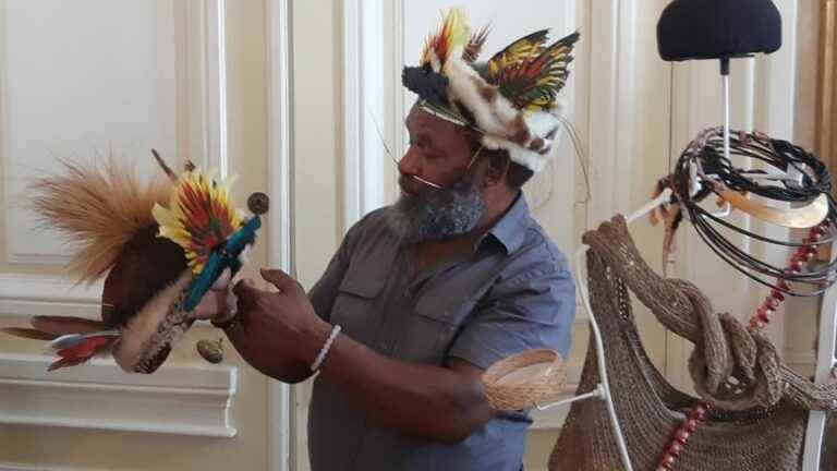 A Papuan chef offers one of his ornaments to raise awareness about deforestation