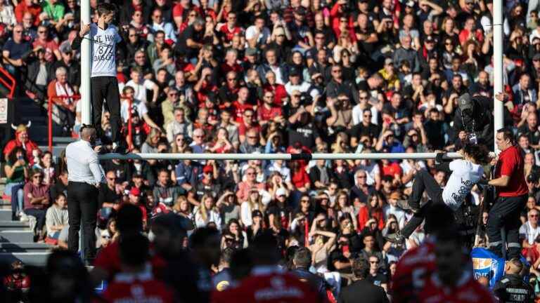 Two environmental activists taken into custody after clinging to poles during the Toulouse-Stade Français rugby match