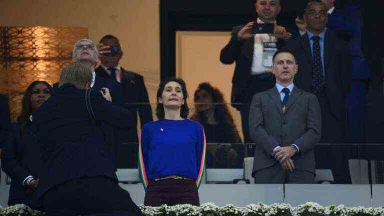 in the stands in Qatar, the Minister of Sports Amélie Oudéa-Castéra wears a blue sweater in the colors of the rainbow