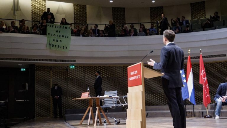 protesters interrupt Emmanuel Macron at the start of a speech in The Hague