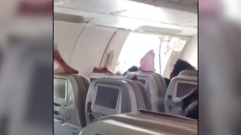 a passenger opens the door of an airplane in mid-flight