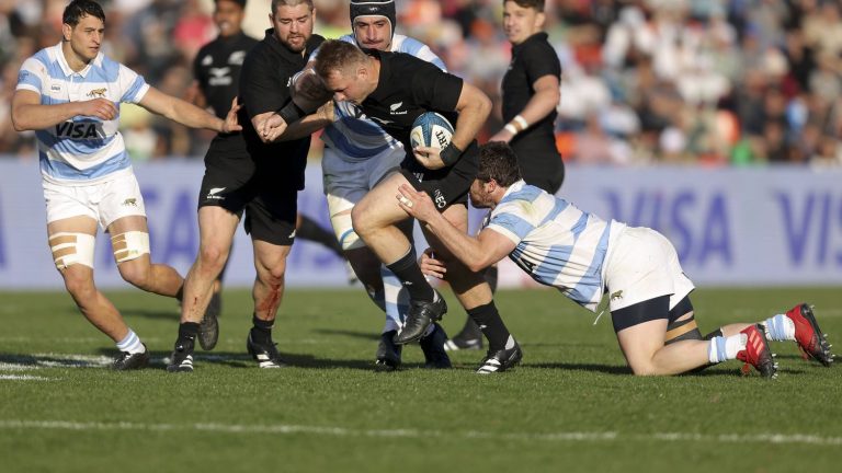 New Zealand captain Sam Cane tackles a spectator on the pitch, then apologizes