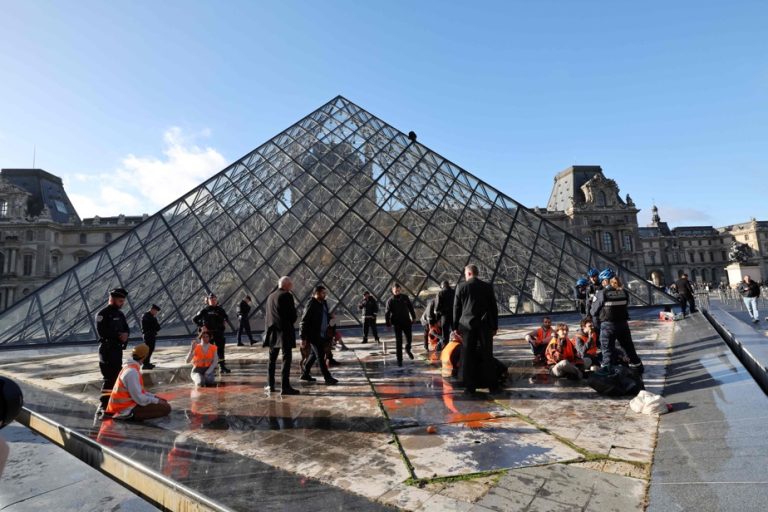 The Louvre pyramid climbed by an environmental activist