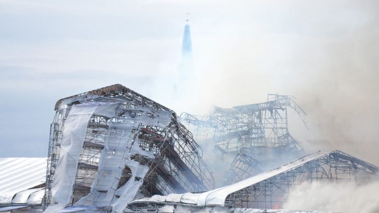 a spectacular fire in progress at the old Copenhagen Stock Exchange, whose spire has collapsed