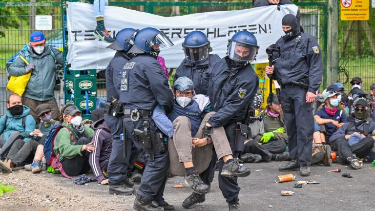 Protesters try to break into a Tesla factory, police push them back