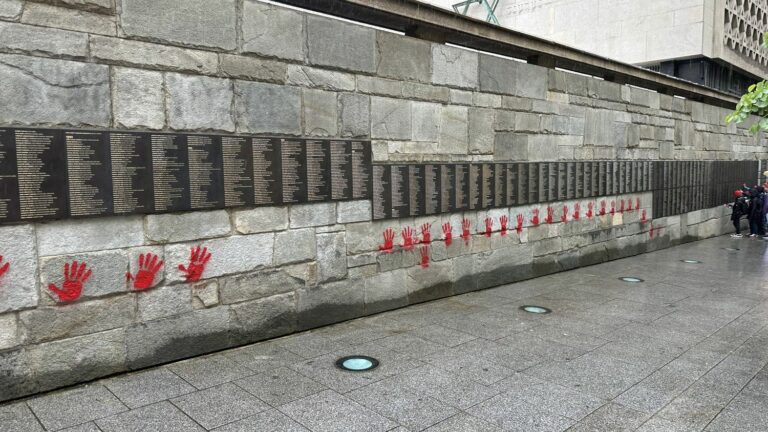 The Wall of the Righteous at the Shoah Memorial vandalized with red hand paint