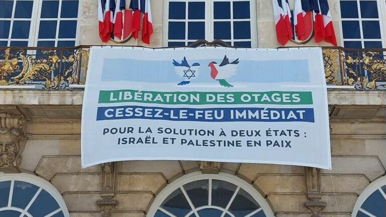 a banner displayed at the front of the town hall to call for peace between Israelis and Palestinians