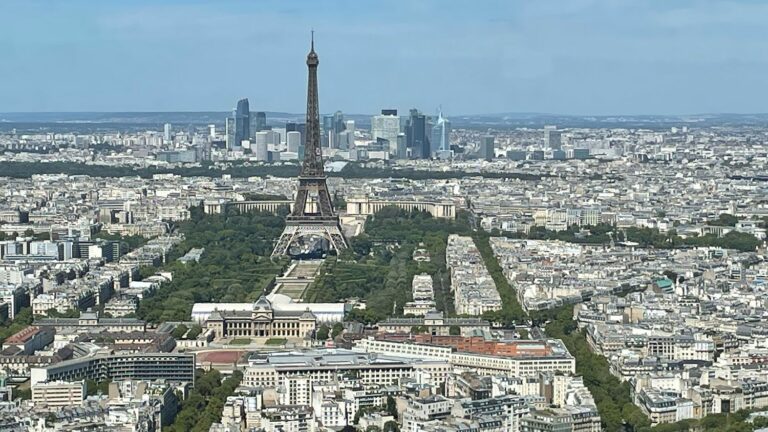 five coffins placed in front of the Eiffel Tower, three people in police custody