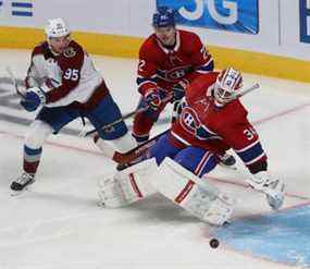 Andre Burakovsky (95) de l'Avalanche du Colorado regarde la rondelle dépasser le gardien des Canadiens de Montréal Jake Allen et Cole Caufield (22) pendant le match où il a marqué en troisième période à Montréal jeudi.  2 décembre 2021.