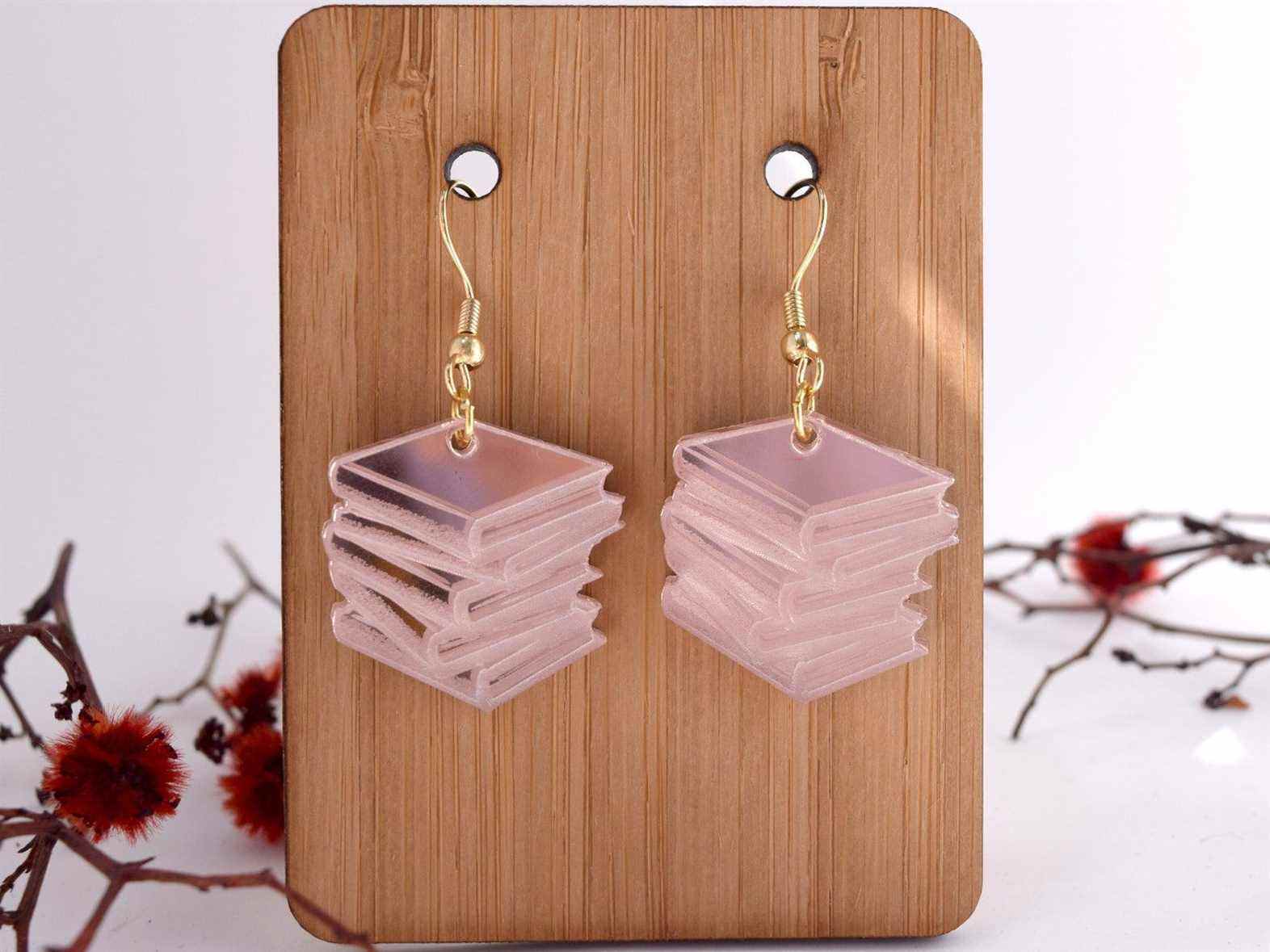 Image d'une paire de boucles d'oreilles en or rose avec pile de livres.