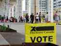 Des gens font la queue devant un bureau de vote pour voter aux élections fédérales, à Toronto, le 20 septembre 2021. 