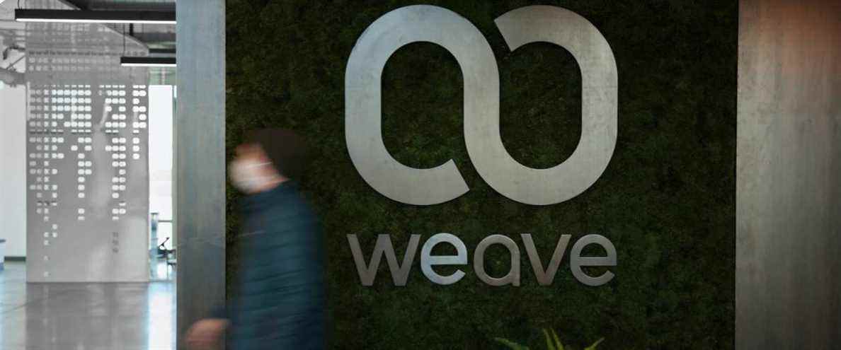 Le logo de Weave Communications sur le mur à l'intérieur d'un immeuble de bureaux