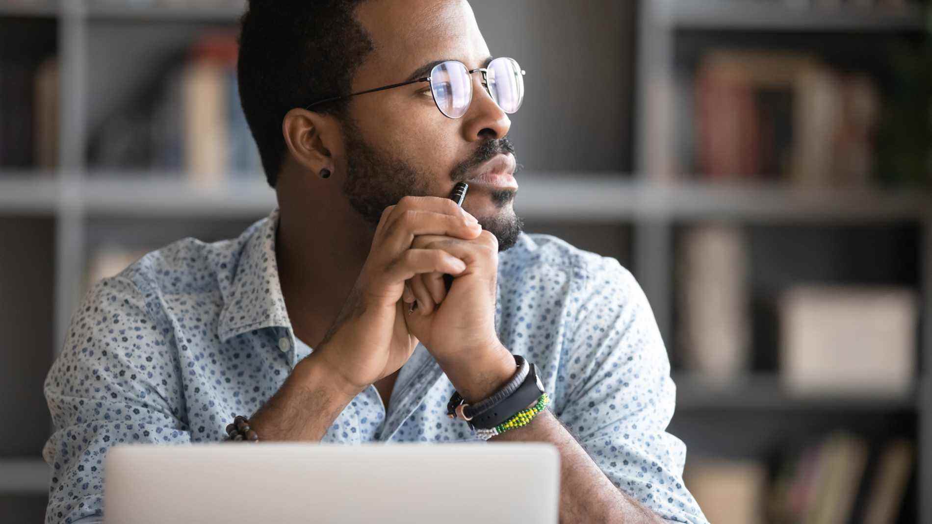 Homme au bureau plongé dans ses pensées