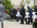 Michael Ciasullo (à gauche) regarde le cercueil de sa fille Lilianna entrer dans l'église catholique St. Eugene De Mazenod à Brampton.  Son épouse Karolina et leurs trois filles Klara, Mila et Lilianna qui ont été tuées jeudi dernier arrivent à l'église pour le service funèbre.