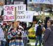 Un manifestant tient une pancarte lors d'une manifestation de verrouillage du COVID-19 à Queen's Park à Toronto, en Ontario.  le samedi 25 avril 2020. 