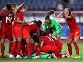 Stéphanie Labbé (cachée) d'Équipe Canada célèbre la victoire avec Julia Grosso (7) et ses coéquipières après avoir sauvé la cinquième pénalité d'Équipe Brésil prise par Rafaelle (pas sur la photo) lors d'une séance de tirs au but lors du match de quart de finale féminin entre le Canada et le Brésil le jour 7 des Jeux Olympiques de Tokyo 2020 au stade Miyagi le 30 juillet 2021, à Rifu, Miyagi, Japon.