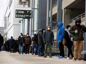 Les gens font la queue pour récupérer les kits de test d'antigène de la maladie à coronavirus (COVID-19), alors que la dernière variante d'Omicron apparaît comme une menace, au Yorkdale Mall à Toronto, Ontario, Canada le 22 décembre 2021