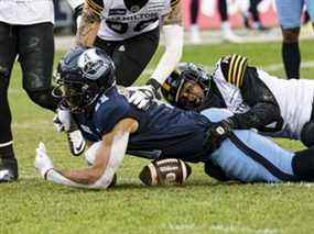 Le receveur large des Argos Juwan Brescacin a une tentative de passe interrompue par le demi défensif des Tiger-Cats de Hamilton Ciante Evans lors de la finale de l'Est hier au BMO Field.