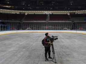 Un journaliste filme en surface où des stars de la LNH auraient joué au Wukesong Sports Center à Pékin, en Chine.