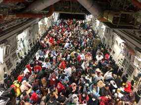 Les personnes évacuées appelées personnes ayant droit au Canada sont assises dans un avion de transport C-177 Globemaster III de l'Aviation royale canadienne (ARC) pour leur vol vers le Canada depuis Kaboul, en Afghanistan, pendant la crise du 23 août 2021. Forces armées canadiennes/Document via REUTERS