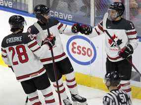 Ryan O'Rourke (28), Elliot Desnoyers (19) et Connor Bedard (16) d'Équipe Canada célèbrent un but en première période contre Équipe Autriche lors du championnat mondial junior de l'IIHF à Edmonton le mardi 28 décembre 2021.