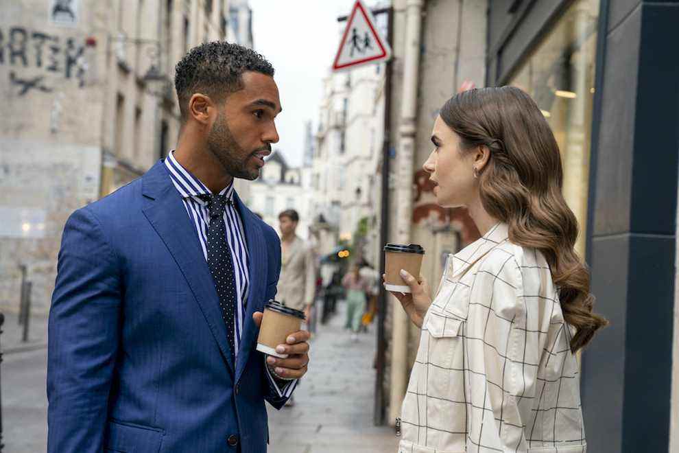 Emilie à Paris.  (L à R) Lucien Laviscount comme Alfie, Lily Collins comme Emily dans l'épisode 205 d'Emily à Paris.  Cr.  Stéphanie Branchu/Netflix © 2021