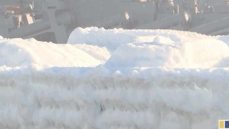 Des voitures arrivent au port couvert de glace salée après que le navire a navigué par mauvais temps