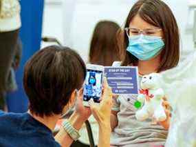 Lily Cho prend une photo de sa fille Harriet Cho après avoir reçu son vaccin dans une clinique de vaccination de l'hôpital Humber River après que le Canada a approuvé le vaccin contre la maladie à coronavirus de Pfizer (COVID-19) pour les enfants âgés de 5 à 11 ans, à Toronto, le 25 novembre 2021.