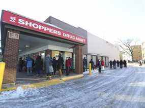 Les gens font la queue devant un Shoppers Drug Mart sur le chemin Royal York.  et The Kingsway pour des injections de rappel le dimanche 19 décembre 2021.