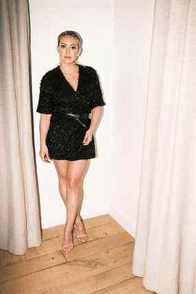 Hilary Duff porte la mini-robe barboteuse Smash + Tess Tinsel en noir minuit.