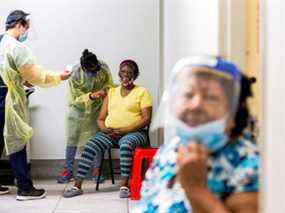 Le docteur Meera Jayarajan et l'infirmière Kevin Sagun de l'hôpital Humber River administrent le vaccin Moderna COVID-19 aux résidents d'un immeuble pour personnes âgées de Toronto Community Housing dans le nord-ouest de Toronto, le 25 mars 2021.