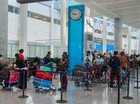 Les passagers de New Delhi attendent dans de longues files d'attente pour être transportés vers leurs hôtels de quarantaine à l'aéroport Pearson de Toronto le vendredi 23 avril 2021.