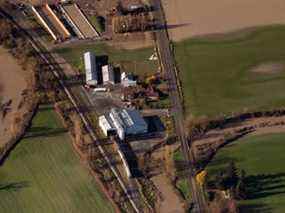 Des wagons sur des voies ferrées entourées de terres agricoles inondées dans la prairie de Sumas près d'Abbotsford, en Colombie-Britannique, au Canada, le vendredi 19 novembre 2021.