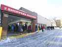 Les gens font la queue devant un Shoppers Drug Mart sur le chemin Royal York.  et The Kingsway pour des injections de rappel le dimanche 19 décembre 2021.  