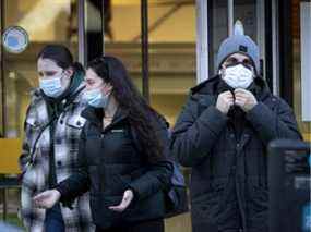 Les gens gardent leur masque lorsqu'ils quittent le bâtiment EV de l'Université Concordia à Montréal le 7 décembre 2021.