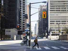 Un piéton traverse la rue Bay dans le quartier financier de Toronto.