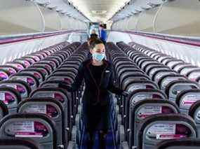 Bloomberg Best of the Year 2020 : un membre de l'équipage de cabine portant un masque de protection vérifie les sièges de la cabine avant le vol à bord d'un avion de passagers exploité par Wizz Air Holdings Plc à l'aéroport de Liszt Ferenc pendant la pandémie de Covid-19 à Budapest, Hongrie, le lundi 25 mai 2020