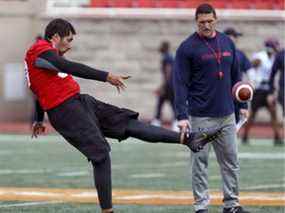 Le coordonnateur des équipes spéciales des Alouettes de Montréal, Mickey Donovan, regarde le botteur Enrique Yenny botté de dégagement lors de la première journée du camp des recrues à Montréal le 15 mai 2019.