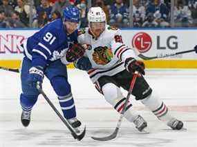 Ryan Carpenter des Blackhawks de Chicago se bat pour la rondelle contre John Tavares des Maple Leafs de Toronto lors d'un match de la LNH au Scotiabank Arena le 11 décembre 2021 à Toronto.