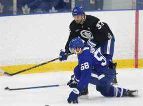 Les Maple Leafs de Toronto Michael Bunting (58 ans) tentent de bloquer une passe de son coéquipier Timothy Liljegren (37 ans) lors d'un entraînement à Toronto le 26 décembre 2021.