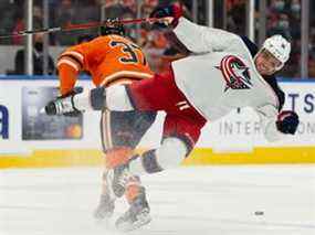 Warren Foegele (37) des Oilers d'Edmonton frappe Max Domi (16) des Blue Jackets de Columbus au Rogers Place à Edmonton le jeudi 16 décembre 2021.