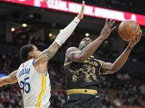 L'attaquant des Raptors de Toronto Precious Achiuwa tire le ballon contre l'attaquant des Golden State Warriors Juan Toscano-Anderson au cours de la seconde moitié à la Scotiabank Arena.