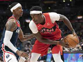 L'attaquant des Raptors de Toronto Pascal Siakam (à droite) contrôle le ballon alors que le gardien des Wizards de Washington Kentavious Caldwell-Pope (à gauche) tente de défendre lors du match d'hier au Scotiabank Arena.