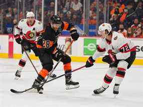 Le centre des Flyers de Philadelphie Claude Giroux (28 ans) contrôle la rondelle contre le défenseur des Sénateurs d'Ottawa Thomas Chabot (72 ans) en première période au Wells Fargo Center.