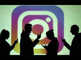 PHOTO DE FICHIER: Des silhouettes d'utilisateurs mobiles sont vues à côté d'une projection d'écran du logo Instagram dans cette illustration photo prise le 28 mars 2018. REUTERS/Dado Ruvic/Illustration/File Photo