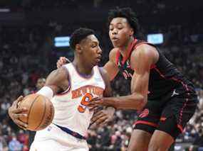 RJ Barrett des Knicks de New York affronte Scottie Barnes des Raptors de Toronto pendant la première moitié de leur match de basket-ball au Scotiabank Arena le 10 décembre 2021 à Toronto.