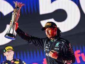 Le pilote britannique Lewis Hamilton, vainqueur de Mercedes, réagit avec son trophée flanqué du pilote néerlandais de Red Bull, Max Verstappen, lors de la cérémonie du podium après le Grand Prix d'Arabie saoudite de Formule 1 sur le circuit de la corniche de Jeddah à Djeddah le 5 décembre 2021 .