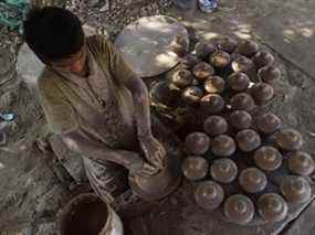 Un enfant potier pakistanais fabrique des tirelires en terre lors d'un atelier à Karachi, le 14 janvier 2019.