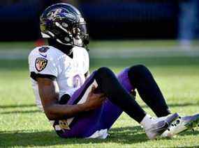 Lamar Jackson des Ravens grimace de douleur après s'être blessé à la cheville contre les Browns à Cleveland hier.  La blessure ne semble pas grave.